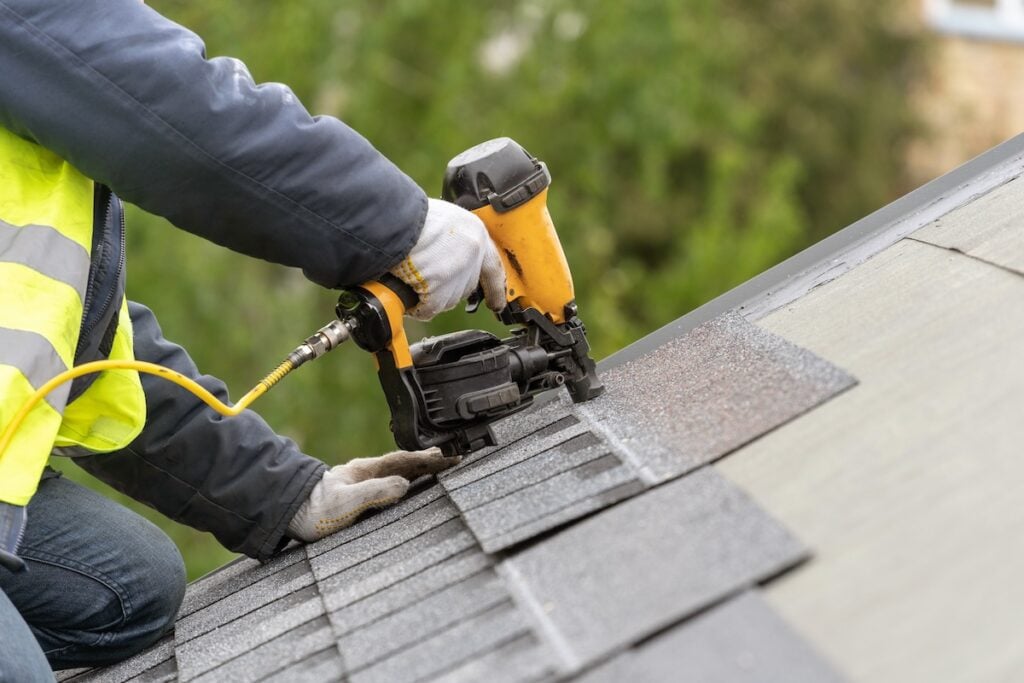 Roofer installing asphalt shingles