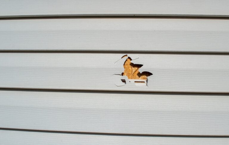 a punctured piece of vinyl siding