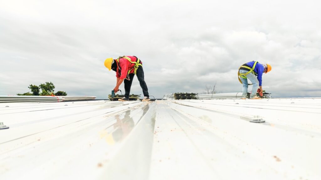 Construction worker install roof, Roofing tools, worke using Electric drill  replacement install roof roof plates.
