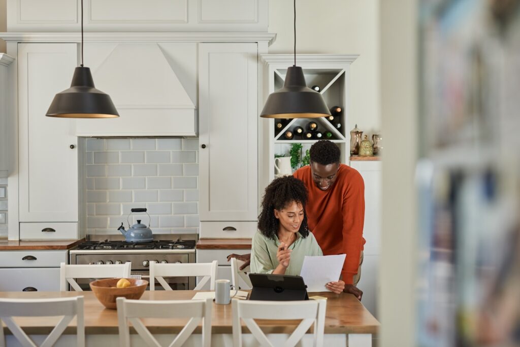 Smiling couple doing their online banking on a tablet at home