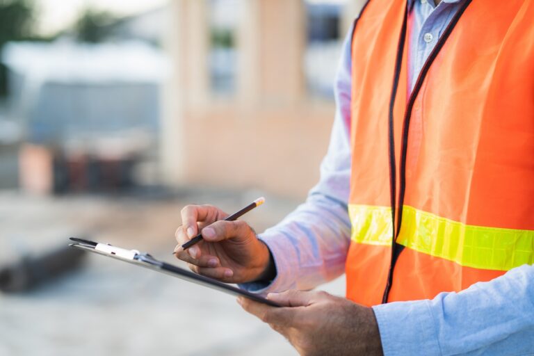 inspector checking structure of new property and taking note in the clipboard for review and fix the house before sell to client