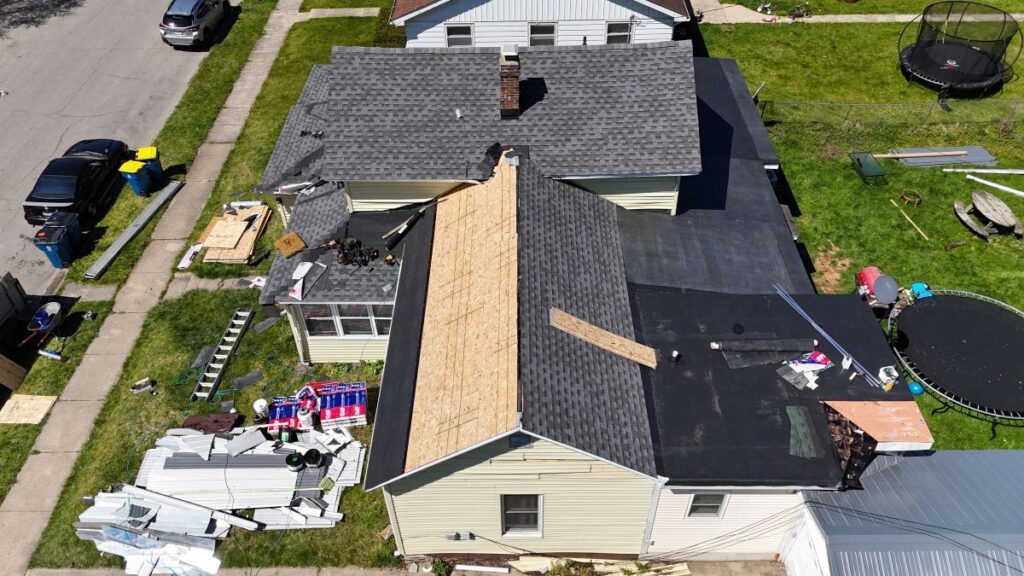 a house with grey asphalt shingles is getting a roof replacement
