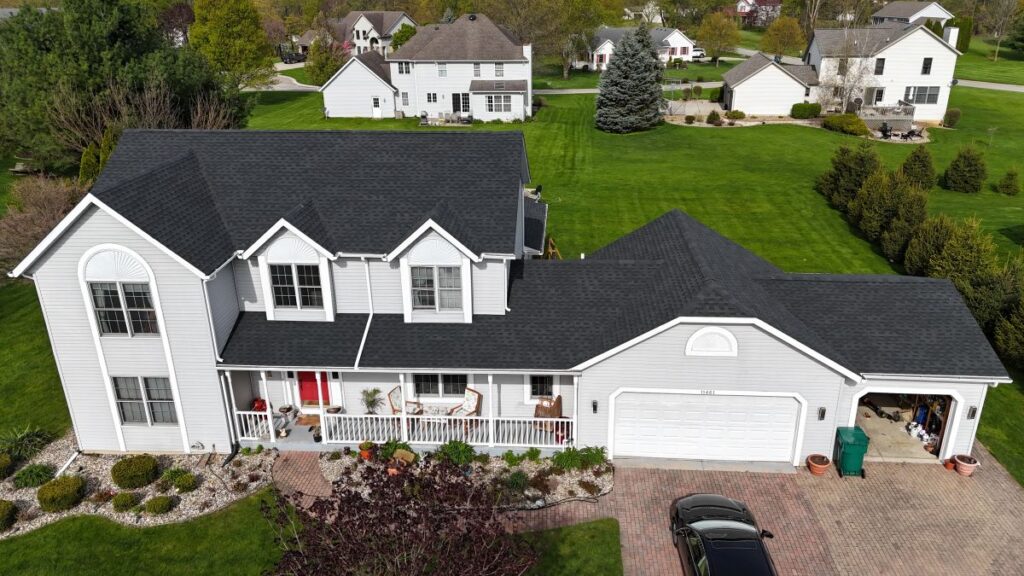 A house with a newly installed dark shingle roof