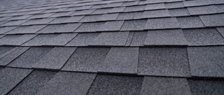 Selective focus texture of dark gray asphalt roof shingles
