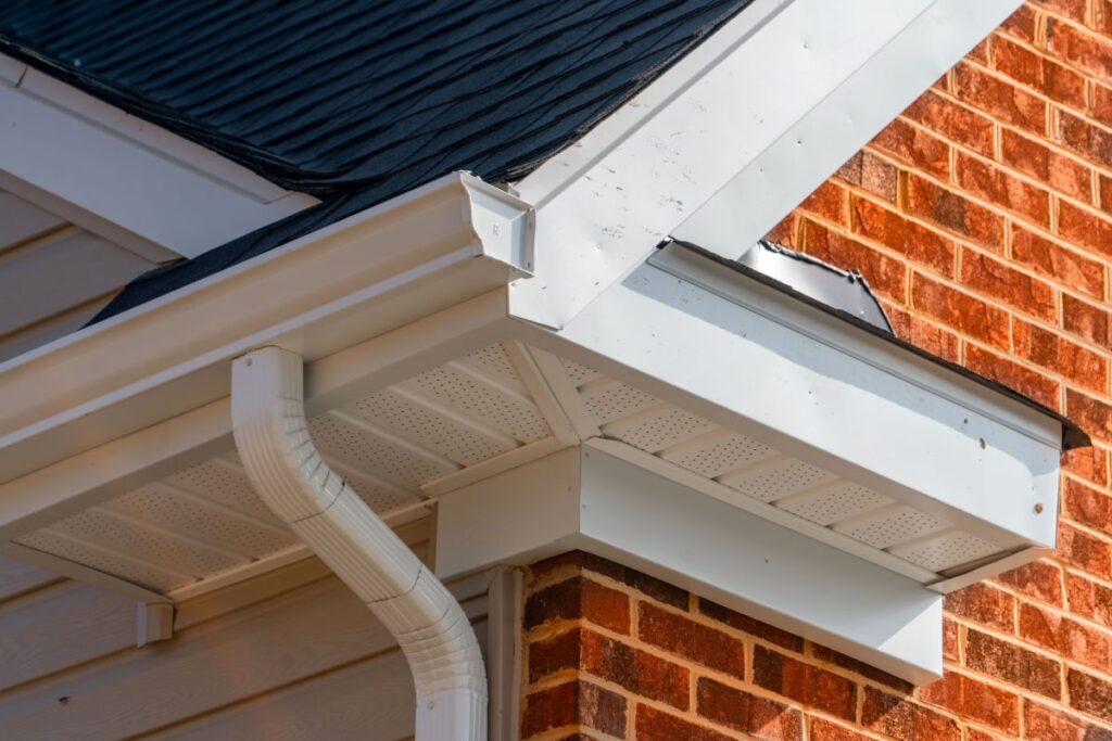 Gable with brick and vinyl siding, white frame gutter guard system, fascia, drip edge, soffit