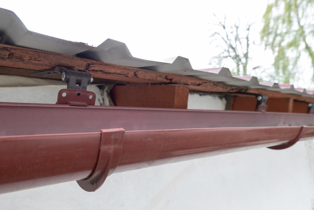 half round copper gutters Gutter system for a metal roof. Holder gutter drainage system on the roof.