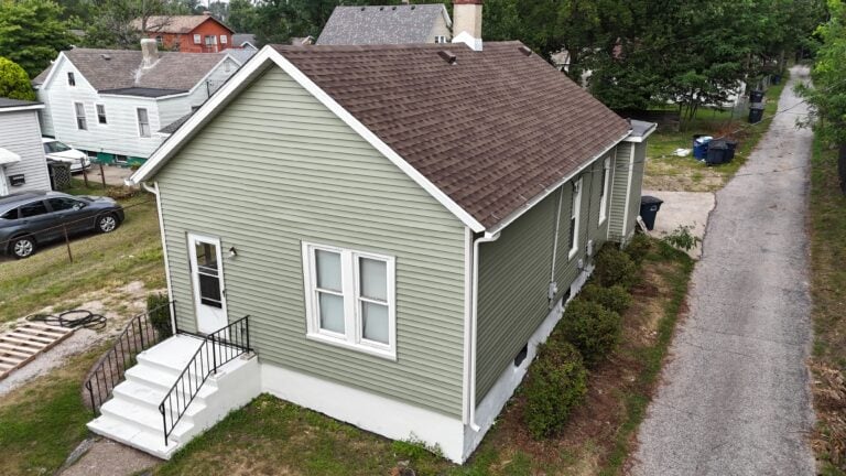 vertical vs horizontal siding green small house with brown shingles roof